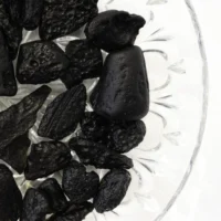 Tektit glas-meteorit som er sort og har en hullet overflade