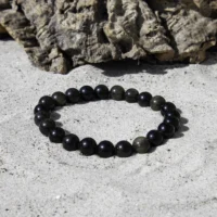 guld obsidian 8 mm armbånd i sort nuance med guld skær.